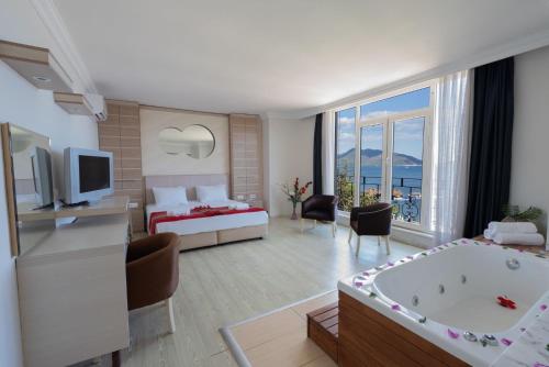 een hotelkamer met een bad en een slaapkamer bij Hotel Caprea in Marmaris