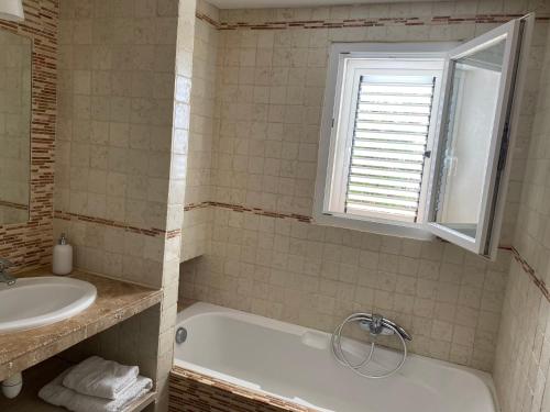 a bathroom with a tub and a sink and a window at Valle Di Casa in Sotta