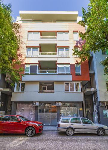 two cars parked in front of a building at Stylish 2BD Apartment with a Nice Cozy Terrace by Flat Mаnager in Plovdiv