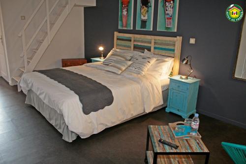 a bedroom with a large bed and a staircase at Le Clos du miroir in Courset