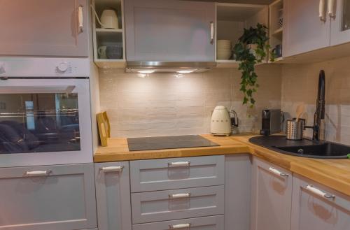 une cuisine avec des armoires blanches et un évier dans l'établissement Nice Vieille Ville Appartement neuf et cosy, deux chambres, 6 couchages, à Nice