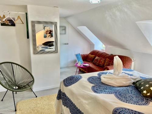 Zimmer mit einem Bett mit einem Stuhl und einem Sofa in der Unterkunft Studio München nahe Olympiapark in München