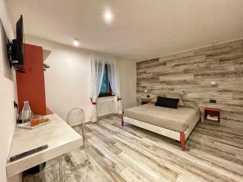 a bedroom with a bed and a wooden wall at Il Gaudente B&B in Santa Fiora