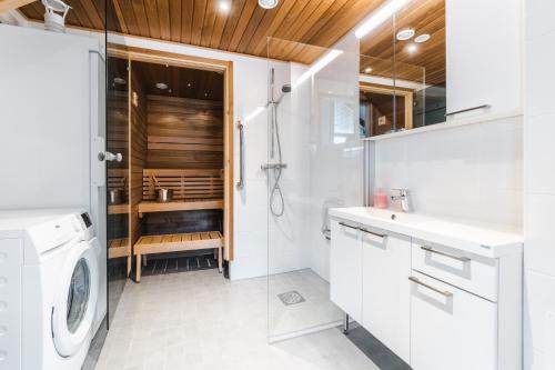 een witte badkamer met een wasmachine en droger bij Holiday in Lapland - Sointuilevi A73 in Levi