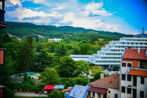 a view of a city with trees and a building at Medius Park Apartment in Sandanski