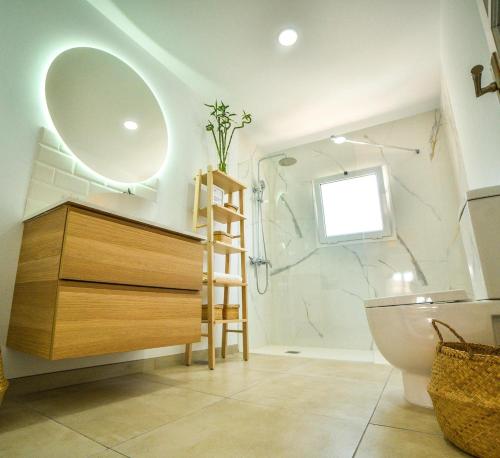 een badkamer met een wastafel, een toilet en een spiegel bij Las Nieves Suites in Teguise