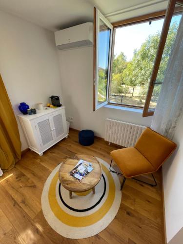 a living room with a table and a chair at Ô Trois Puits in Laburgade
