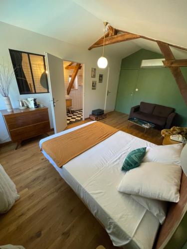 sypialnia z dużym łóżkiem i kanapą w obiekcie Ô Trois Puits w mieście Laburgade