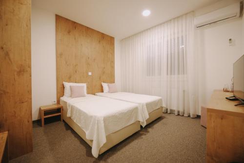 a bedroom with a large white bed and a window at ATOS Centar in Čelinac