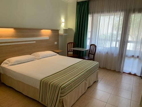 ein Hotelzimmer mit einem großen Bett und einem Tisch in der Unterkunft Apartamentos Tinoca in Las Palmas de Gran Canaria