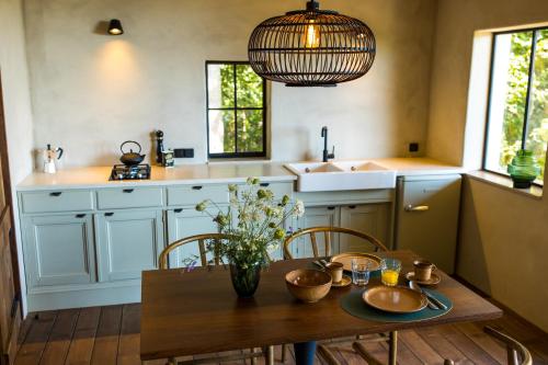 - une cuisine avec une table, des chaises et un évier dans l'établissement The cabin Morris, à Holsbeek