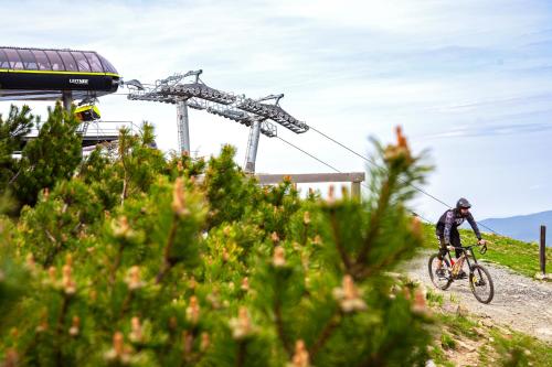 a man riding a bike down a dirt road at Aparthotel Apartamenty Czarna Góra 330 in Sienna