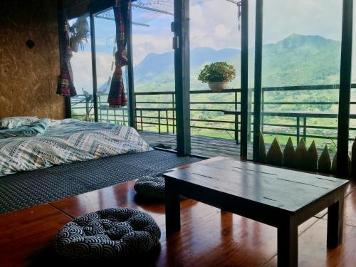 een slaapkamer met een bed en een tafel en uitzicht bij Thuyền mây Sapa homestay in Sa Pa