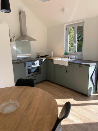 une cuisine avec une table, un évier et une cuisinière dans l'établissement Petite maison Conjat, à Saint-Julien-le-Petit