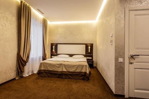 a hotel room with a bed and a window at Optima Collection Khmelnytskyi in Khmelʼnytsʼkyy