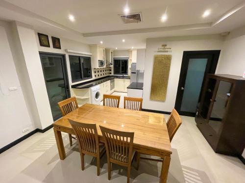 a kitchen and dining room with a wooden table and chairs at Private Pool & Jacuzzi Villa, Phratumnak, Pattaya - 600m from the beach, 711 nearby in Pattaya South