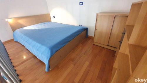 a bedroom with a blue bed and a wooden cabinet at House of Music - Bari Centro in Bari