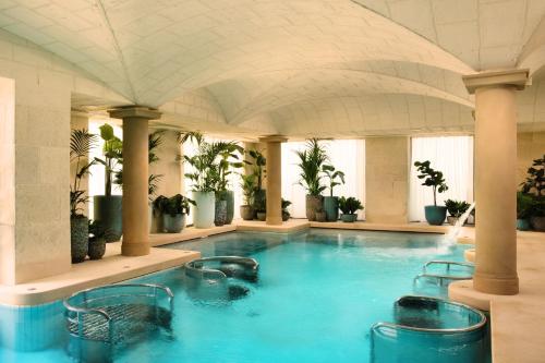 a large swimming pool in a building with plants at Grantley Hall in Ripon