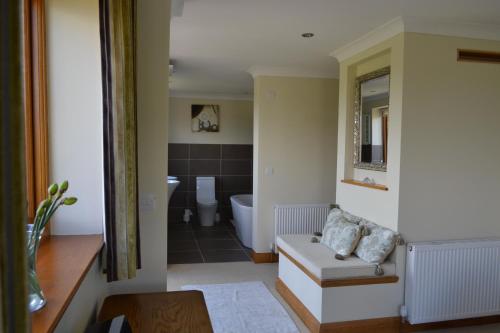 a bathroom with a toilet and a bath tub at Mutton Barn in Alcester