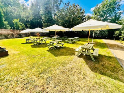 a group of picnic tables and umbrellas on the grass at George & Dragon Hotel in Buckinghamshire