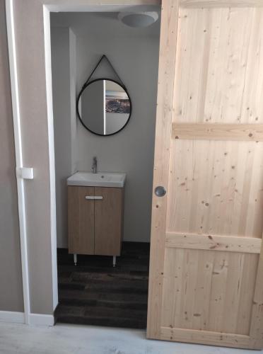 La salle de bains est pourvue d'un lavabo et d'une porte en bois. dans l'établissement La maison du Pêcheur, à Grand-Fort-Philippe