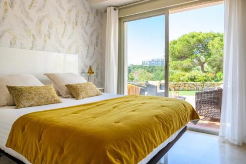 オリフエラ・コスタにあるLas Colinas Golf & Country Club Residencesのベッドルーム(大きな黄色のベッド1台、大きな窓付)