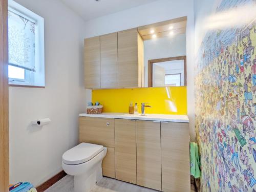 een badkamer met een toilet, een wastafel en een spiegel bij Innisfree, Middleton on Sea in Middleton-on-Sea