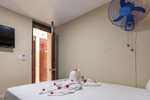 a room with a bed with towels and a fan at Hotel Turístico Marian in Las Terrenas