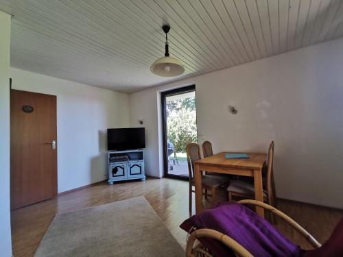 a living room with a table and a television at Haus Buron in Titisee-Neustadt