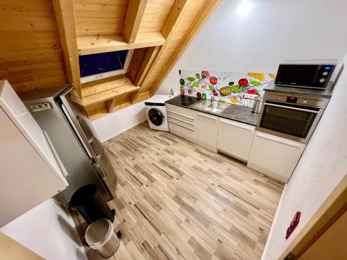 a small kitchen with white cabinets and wooden floors at Familie Ising in Wörnitz