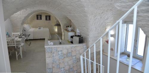 Habitación con lavabo y habitación con mesa en Attico Cinquantasei, en Cisternino