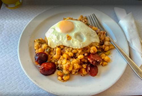 a plate of food with an egg on top at Pam de Terra in Palha Carga