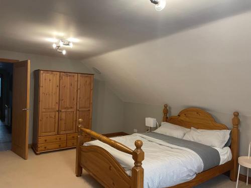 1 dormitorio con cama de madera y tocador de madera en Fabulous 2 Bed Apartment en Penrith