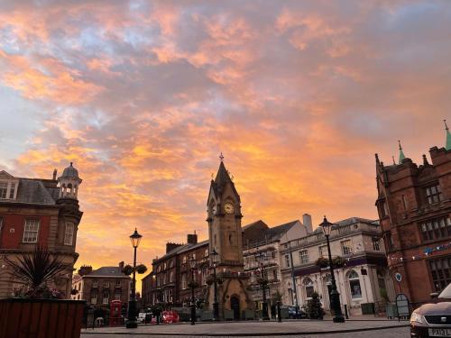 a clock tower in a city with a cloudy sky at Fabulous 2 Bed Apartment in Penrith
