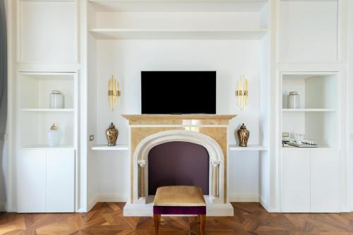 a living room with a fireplace and a tv at Grand Hotel Des Etrangers in Siracusa