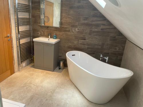 a bathroom with a white tub and a sink at Fabulous 2 Bed Apartment in Penrith