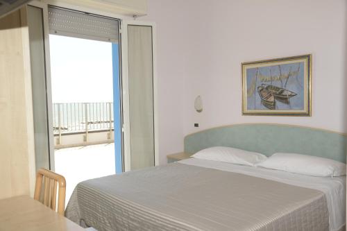 a bedroom with a bed and a large window at Residence Hotel Amalfi in Lido di Savio