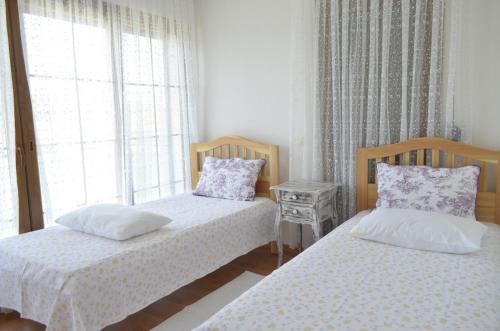 a bedroom with two beds and a window at Nalyakonak in Alacati