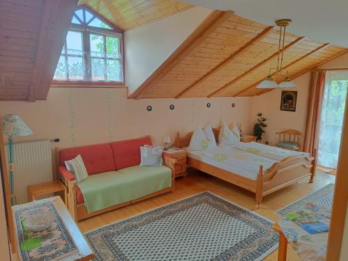 a bedroom with a bed and a couch in a room at Haus Sundl - Privatzimmer in Emmersdorf an der Donau