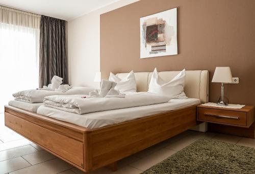 1 dormitorio con 1 cama grande con almohadas blancas en Hotel Fruerlund, en Flensburg