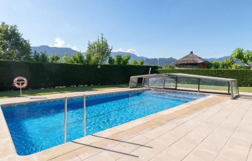 een zwembad in een tuin met een hek bij Hotel Restaurant Cal Petit in Oliana