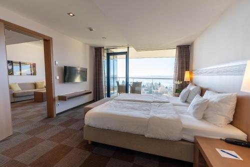 a hotel room with a large bed and a living room at Parkhotel St.Leonhard in Überlingen
