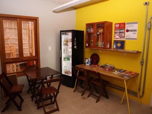 a dining room with a table and a refrigerator at MADÁ hostel in Sao Paulo