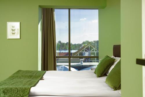 a bedroom with a bed and a large window at Kamienica Portowa in Mikołajki