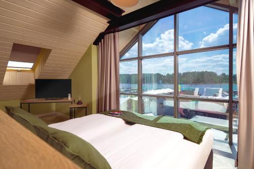 a bedroom with a large window with a view of a marina at Kamienica Portowa in Mikołajki