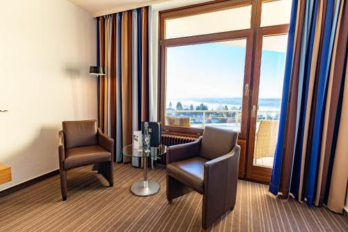 a room with two chairs and a table and a window at Parkhotel St.Leonhard in Überlingen