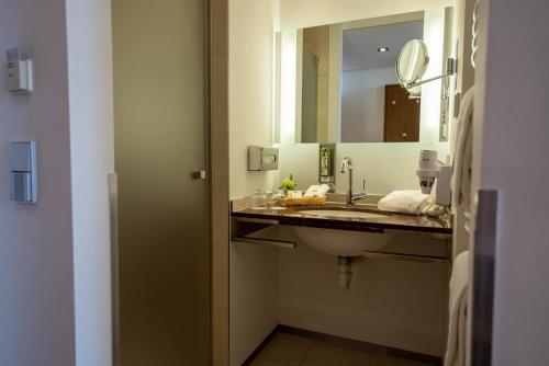 a bathroom with a sink and a mirror at Parkhotel St.Leonhard in Überlingen