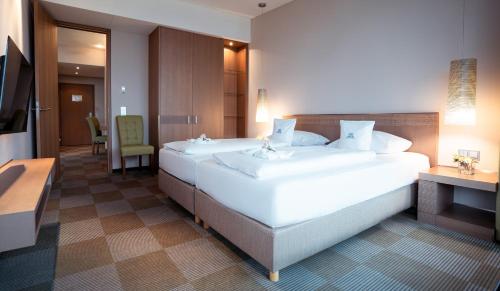a large white bed in a hotel room at Parkhotel St.Leonhard in Überlingen