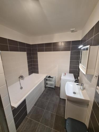 y baño con bañera y lavamanos. en Apartmán Kuba, en Frymburk