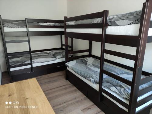 2 łóżka piętrowe w pokoju z drewnianym stołem w obiekcie Apartmán Kuba w mieście Frymburk